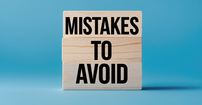Wooden blocks stacked with the words "MISTAKES TO AVOID" against a blue background.